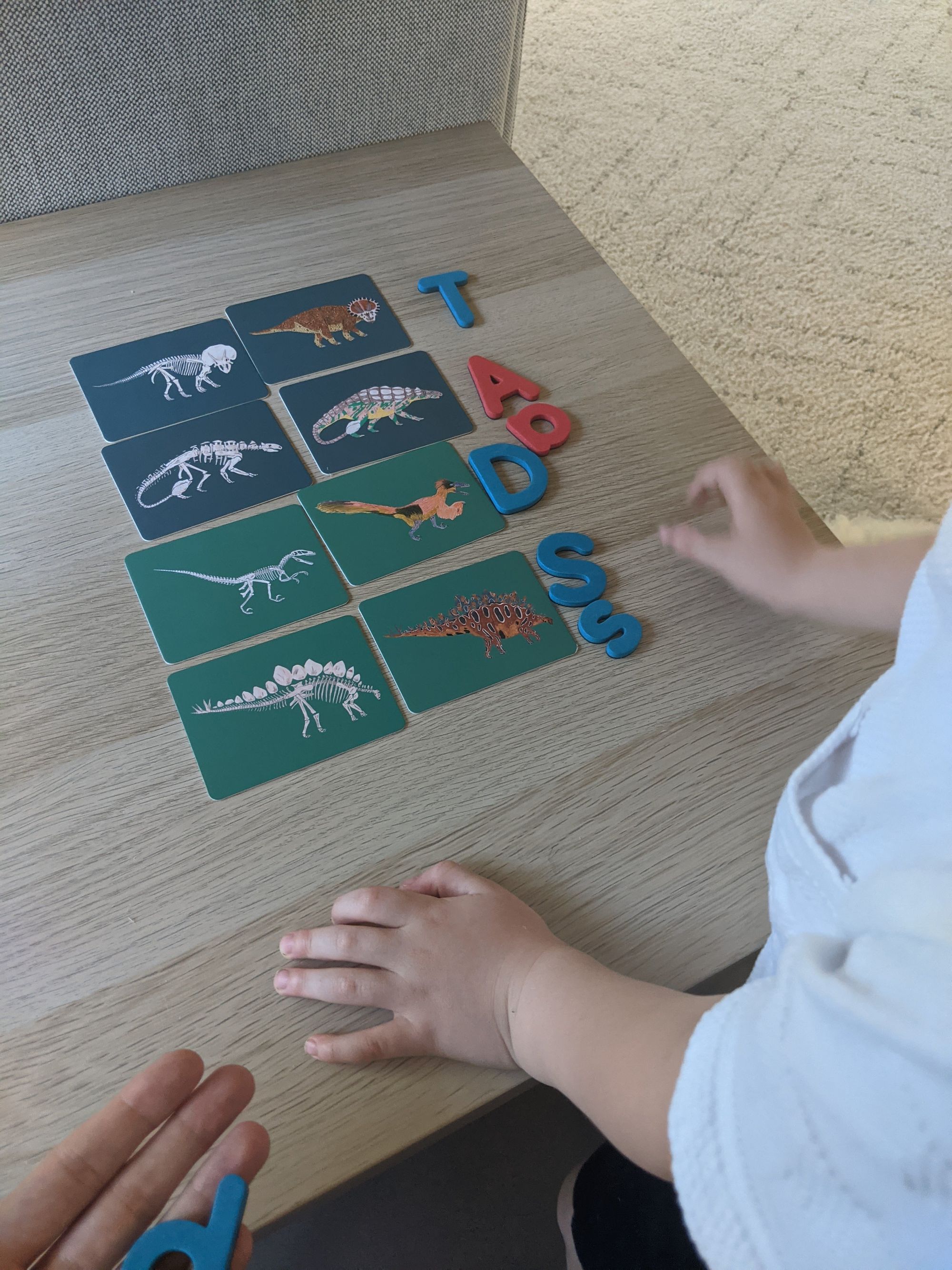Hands arranging letter cards on a tray