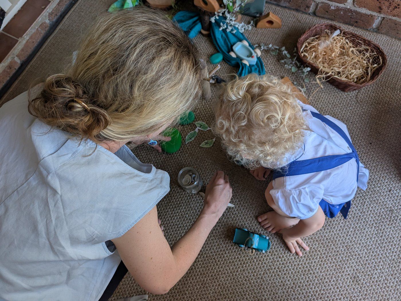 A parent playing a reading game with a young child on a rug